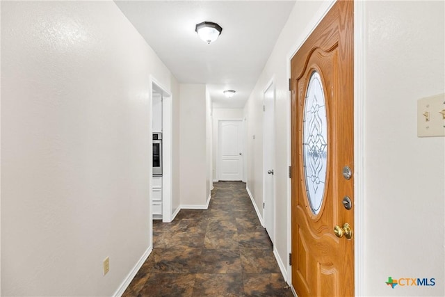 foyer featuring stone finish floor and baseboards