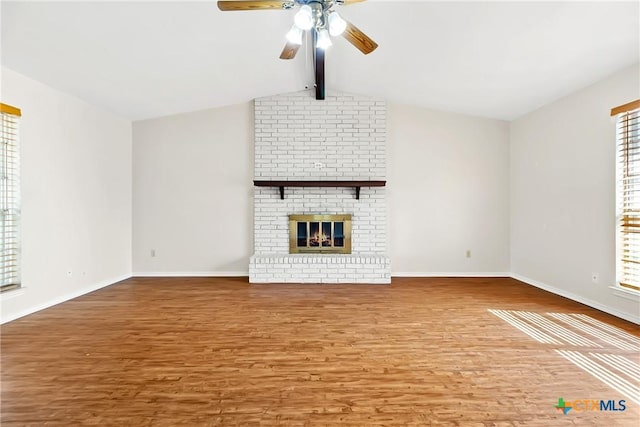 unfurnished living room featuring a brick fireplace, vaulted ceiling with beams, baseboards, wood finished floors, and a ceiling fan