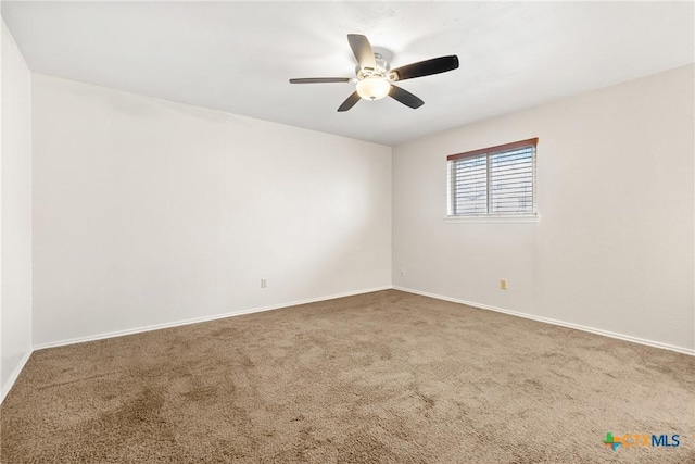 carpeted spare room with baseboards and ceiling fan