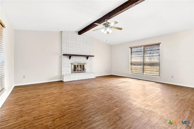 unfurnished living room featuring a ceiling fan, a brick fireplace, vaulted ceiling with beams, and wood finished floors