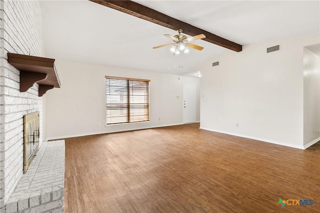 unfurnished living room with visible vents, lofted ceiling with beams, wood finished floors, a brick fireplace, and ceiling fan