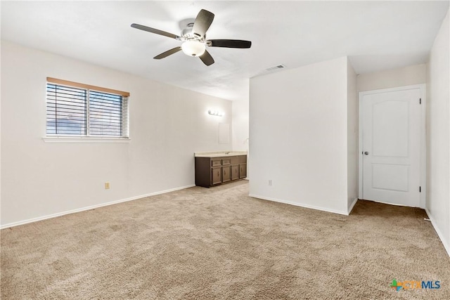 unfurnished bedroom featuring ensuite bath, baseboards, visible vents, and light carpet