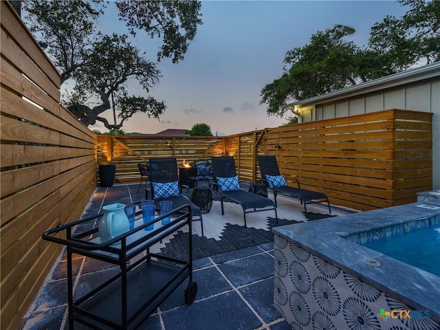 patio terrace at dusk with a fenced backyard