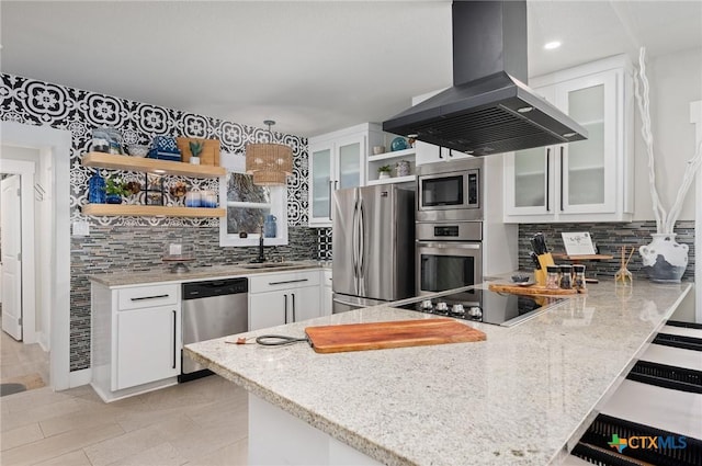 kitchen featuring open shelves, island range hood, stainless steel appliances, backsplash, and a peninsula