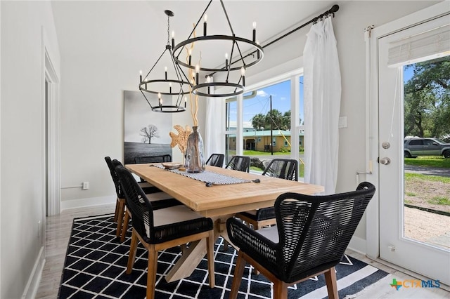 dining space with baseboards and a notable chandelier