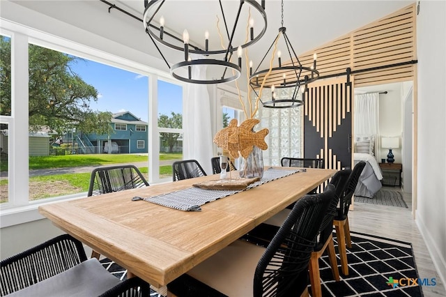 dining area featuring wood finished floors, baseboards, a chandelier, and a healthy amount of sunlight