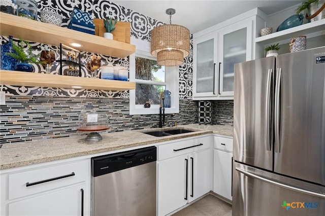 kitchen with open shelves, stainless steel appliances, a sink, and tasteful backsplash