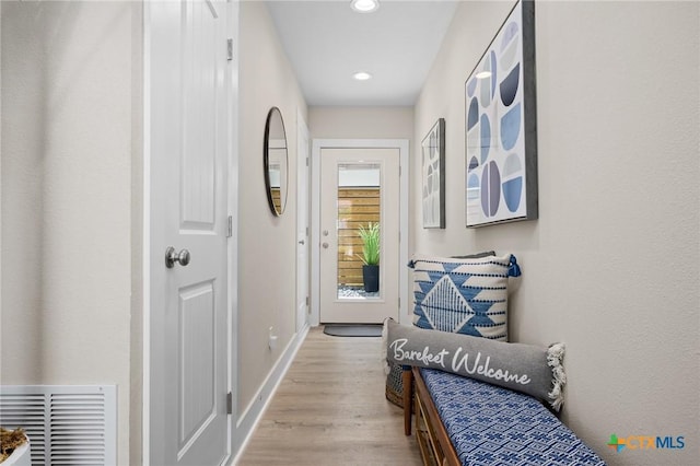 corridor with baseboards, wood finished floors, visible vents, and recessed lighting