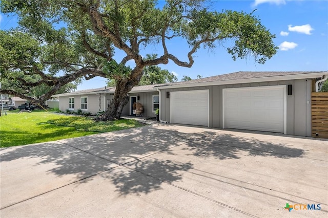 ranch-style house featuring a garage, driveway, and a front lawn