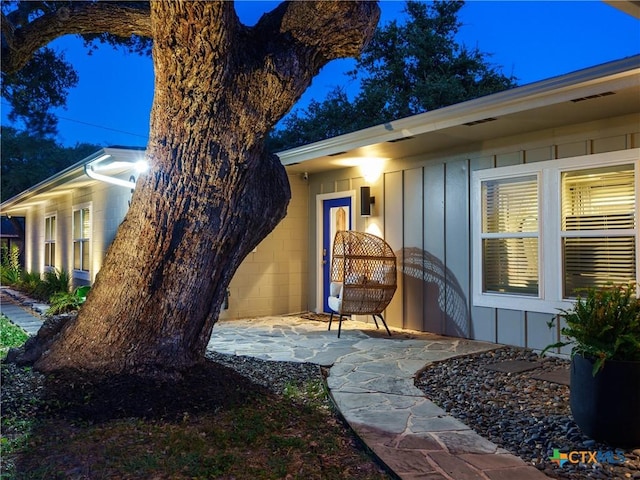 property entrance featuring board and batten siding and concrete block siding