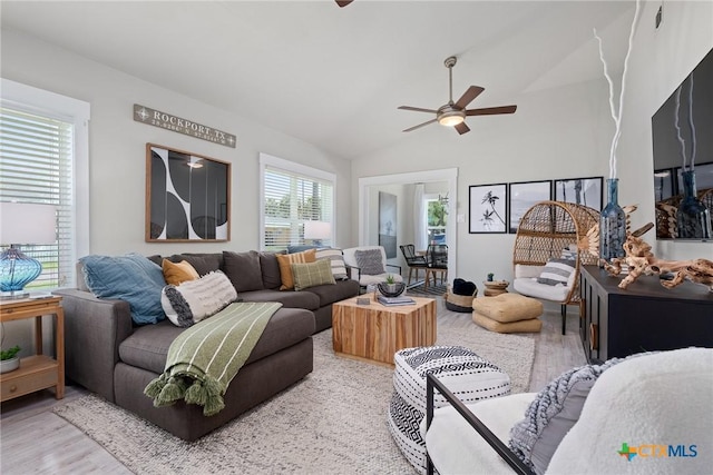 living room featuring light wood-style floors, lofted ceiling, and ceiling fan