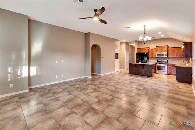 kitchen featuring lofted ceiling, a center island, hanging light fixtures, stainless steel appliances, and ceiling fan with notable chandelier