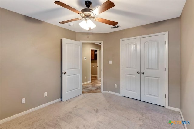 unfurnished bedroom featuring light colored carpet, ceiling fan, and a closet