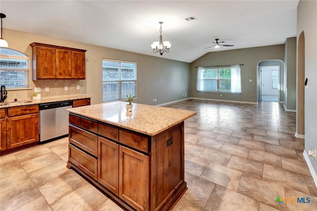 kitchen with hanging light fixtures, backsplash, stainless steel dishwasher, and a kitchen island