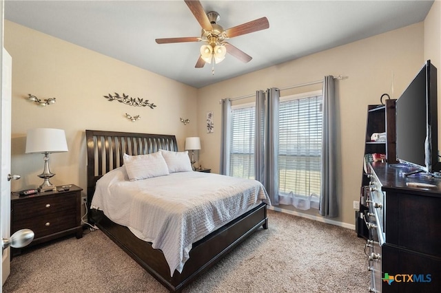 bedroom with light colored carpet, baseboards, and a ceiling fan