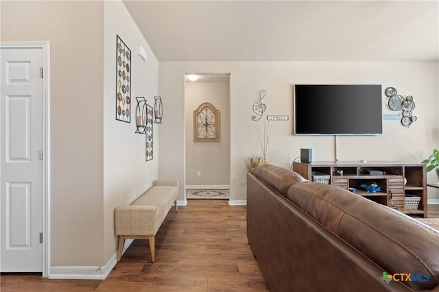 living area featuring baseboards and wood finished floors
