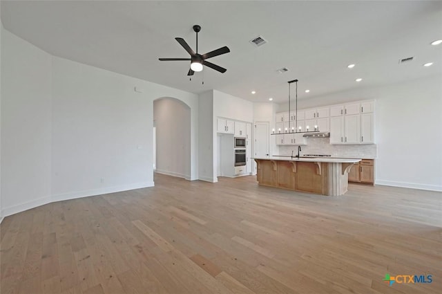 367 Five Mile Creek Way, Kyle, TX 78640 - kitchen featuring stainless steel appliances, open floor plan, arched walkways, and recessed lighting