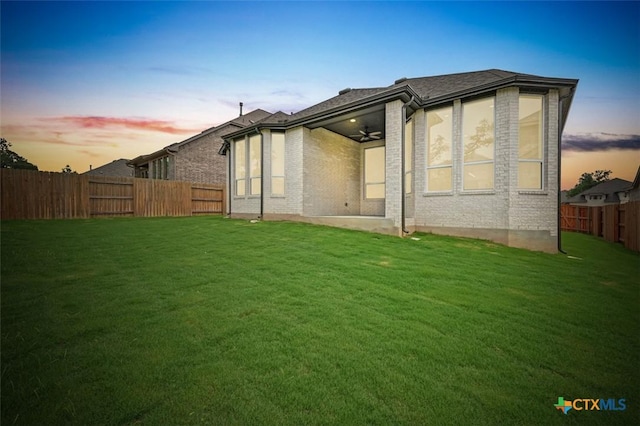 367 Five Mile Creek Way, Kyle, TX 78640 - back of property at dusk featuring a fenced backyard, ceiling fan, and brick siding