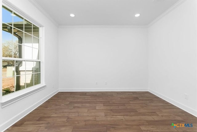 empty room featuring plenty of natural light, dark wood-type flooring, and ornamental molding