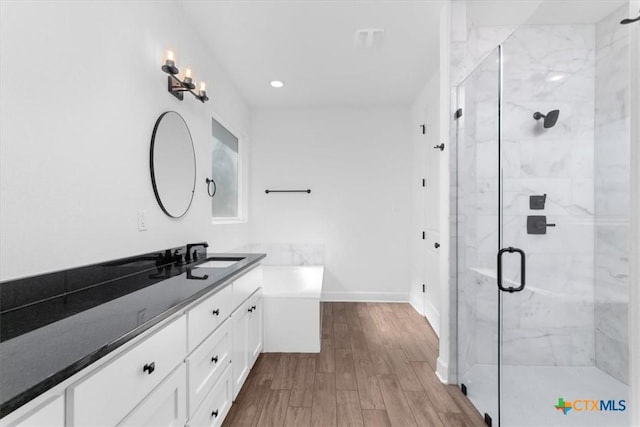 bathroom with vanity, independent shower and bath, and wood-type flooring