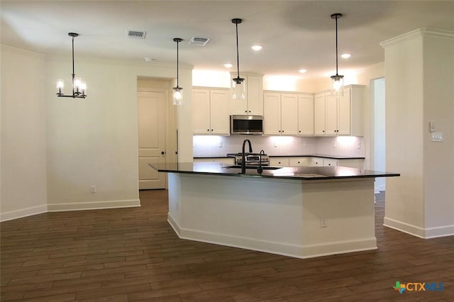 kitchen with white cabinetry, stainless steel appliances, dark hardwood / wood-style floors, and hanging light fixtures