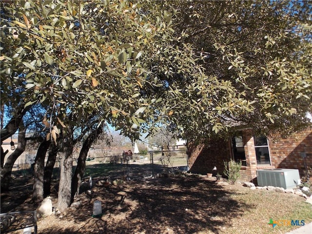 view of yard with fence and central AC unit