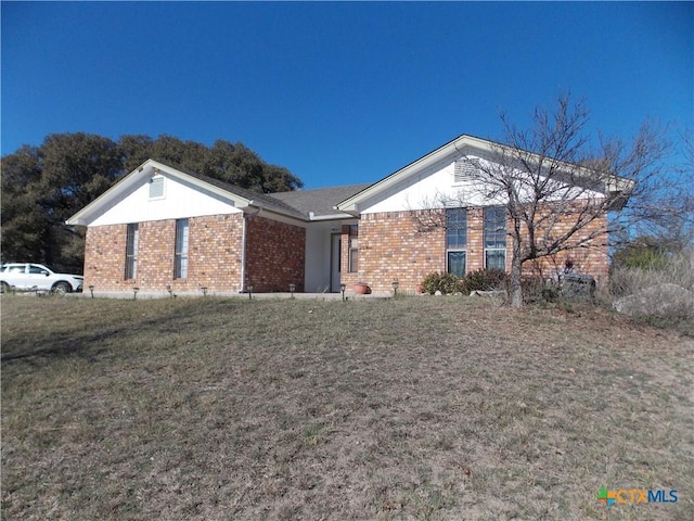 single story home featuring a front yard and brick siding