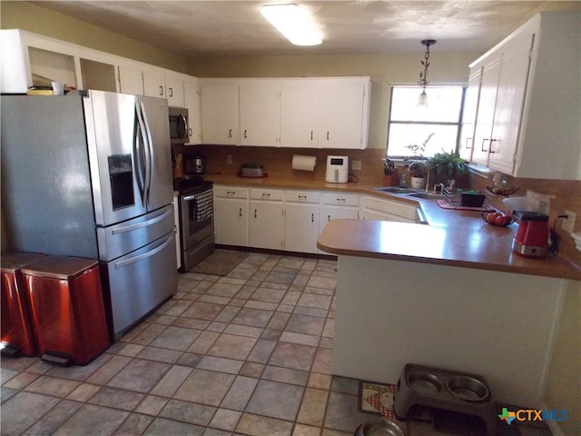 kitchen featuring sink, white cabinetry, hanging light fixtures, and appliances with stainless steel finishes