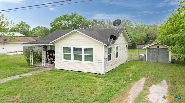 704 Maple St, Yoakum, TX 77995 - rear view of house with a yard, dirt driveway, and an outbuilding