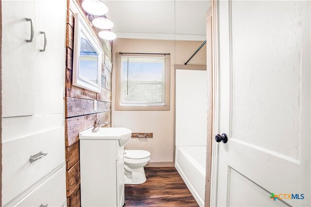 704 Maple St, Yoakum, TX 77995 - full bathroom featuring vanity, wood finished floors, shower / washtub combination, and crown molding