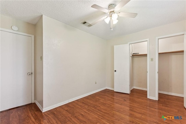 2601 Traverse Dr, Killeen, TX 76543 - unfurnished bedroom featuring two closets, wood finished floors, a ceiling fan, and a textured ceiling