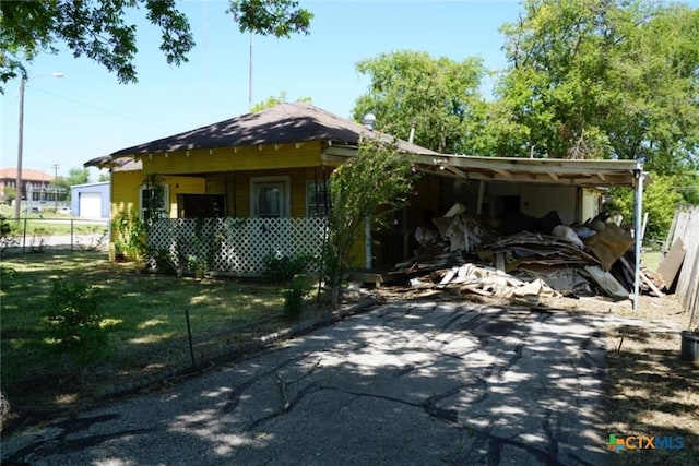 view of front of property featuring a front lawn and a carport