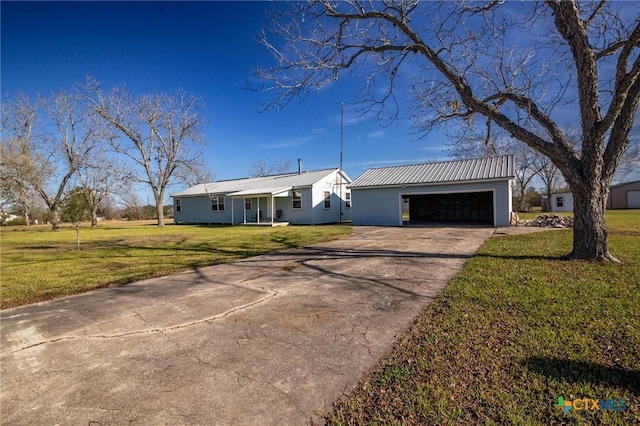 view of front of home with a garage, an outdoor structure, and a front yard