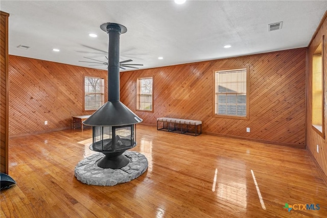 misc room featuring a wood stove and wooden walls