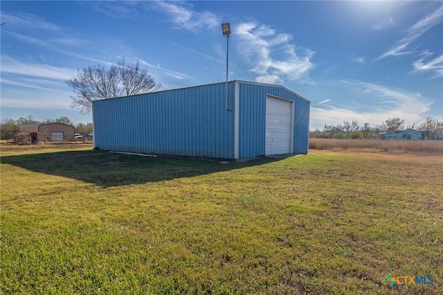 view of outbuilding featuring a garage and a yard