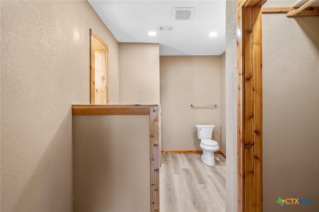 bathroom featuring hardwood / wood-style floors and toilet