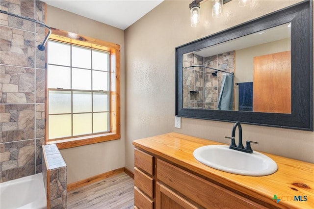 bathroom with hardwood / wood-style floors, vanity, and shower / bath combo