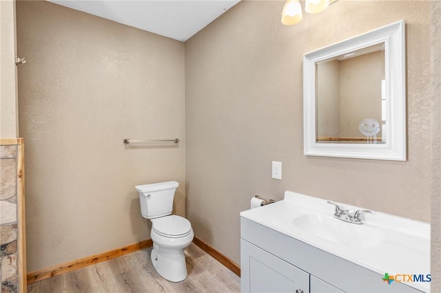 bathroom featuring wood-type flooring, vanity, and toilet