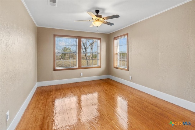 empty room with ceiling fan, wood-type flooring, and crown molding