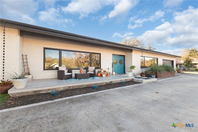 back of property featuring an outdoor living space and a patio area