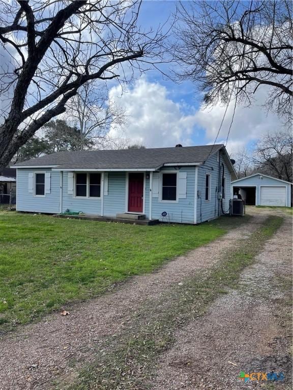 view of front of house with a garage, an outdoor structure, central AC unit, and a front lawn