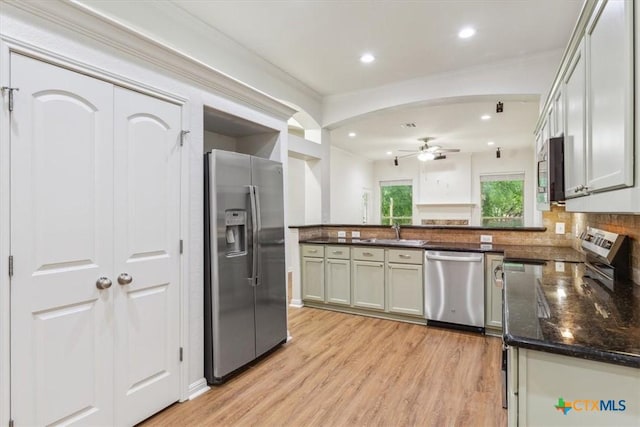 3306 Spring Canyon Rd, Belton, TX 76513 - kitchen featuring a peninsula, dark stone countertops, a ceiling fan, light wood-style flooring, and stainless steel appliances