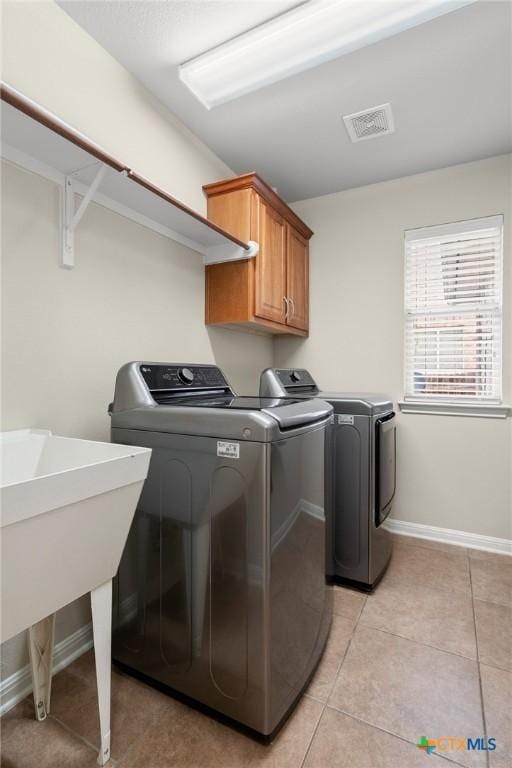101 Payne Stewart Dr, Round Rock, TX 78664 - laundry room featuring cabinet space, washing machine and dryer, and light tile patterned flooring