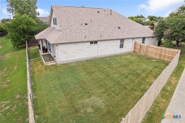 101 Payne Stewart Dr, Round Rock, TX 78664 - rear view of property with a shingled roof, a fenced backyard, and stone siding