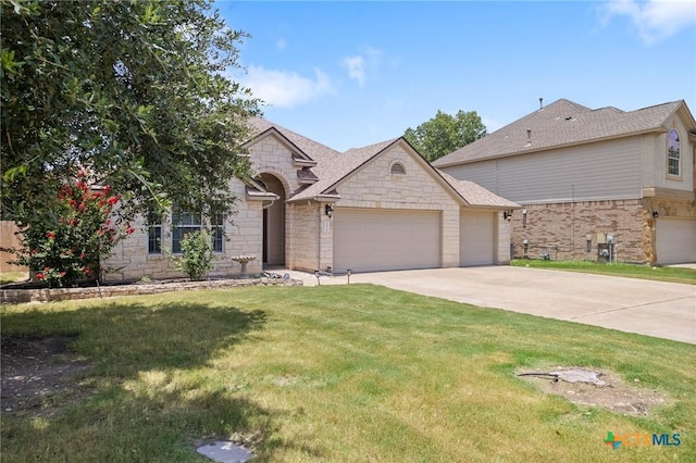 101 Payne Stewart Dr, Round Rock, TX 78664 - french country inspired facade with a garage, stone siding, concrete driveway, a front lawn, and a shingled roof