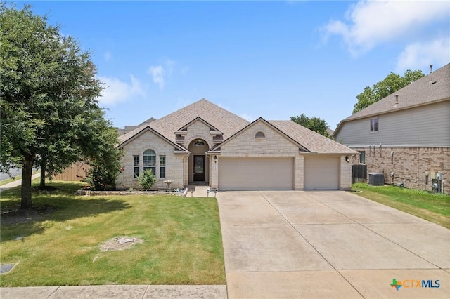 101 Payne Stewart Dr, Round Rock, TX 78664 - french provincial home featuring a garage, driveway, stone siding, and a front yard