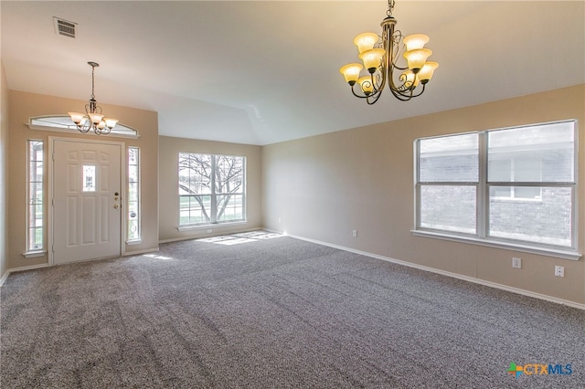 carpeted foyer with a notable chandelier and vaulted ceiling