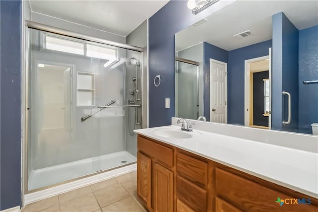 bathroom with visible vents, a stall shower, tile patterned flooring, and vanity