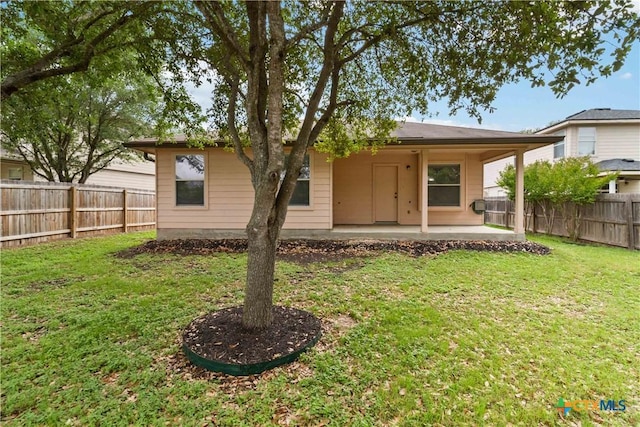 back of house featuring a yard, a patio area, and a fenced backyard