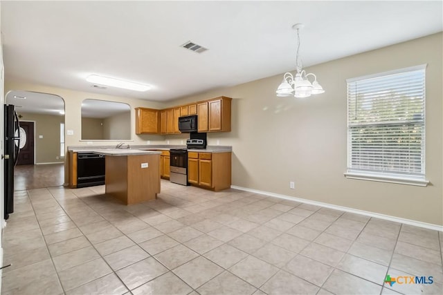 kitchen with arched walkways, light tile patterned floors, light countertops, black appliances, and visible vents